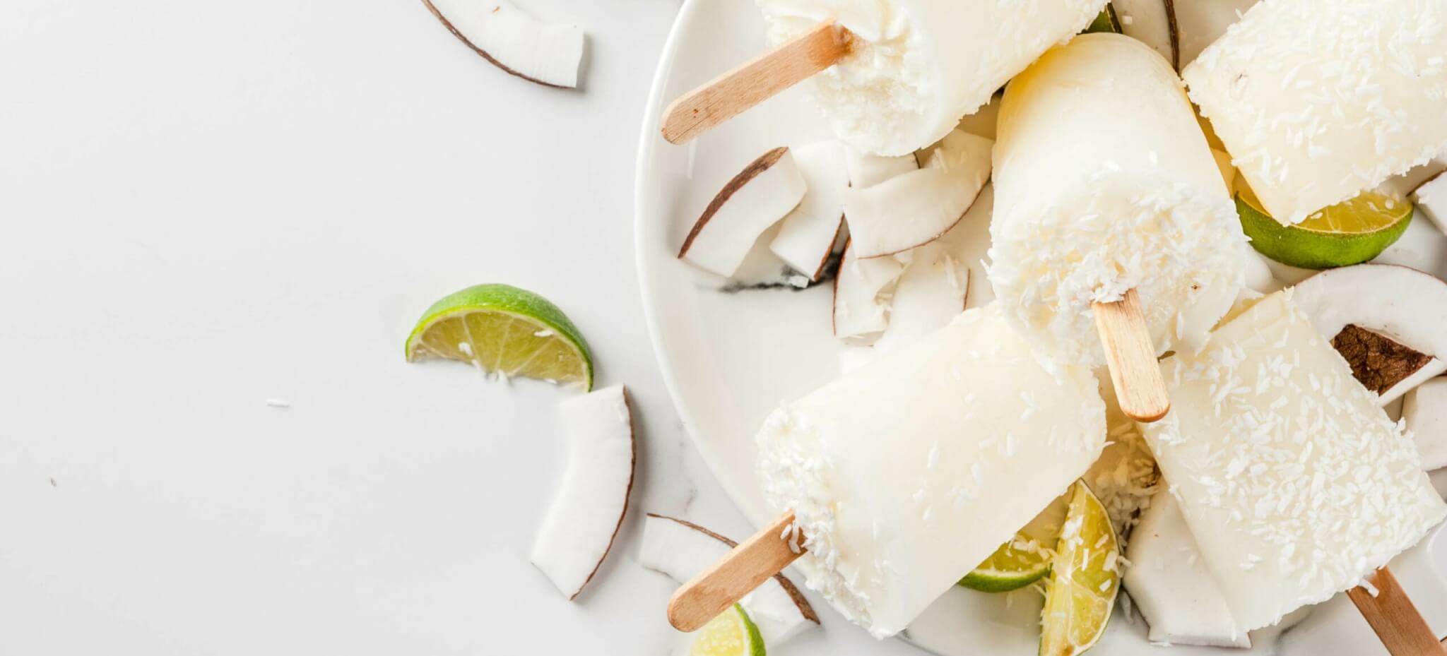 weißes selbstgemachtes Protein Eis am Stil mit Limetten und Kokosraspel